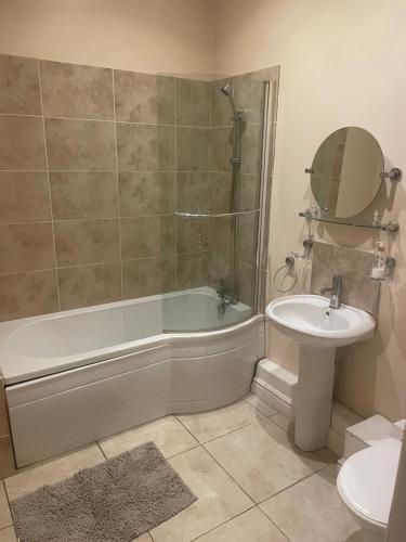 a bathroom with a tub and a sink and a toilet at Dolphin Inn in Llanymynech