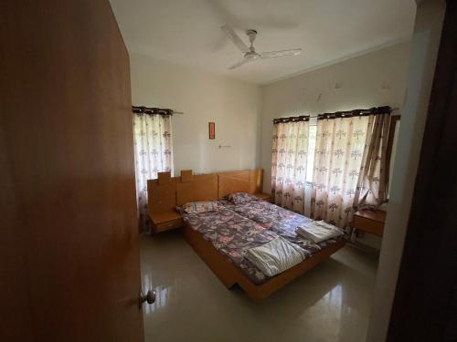 a bedroom with a bed and two windows at Samruddhi S3 homestay garden villa or S1 in Nagpur