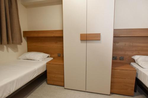 a bedroom with two beds and a closet at 51HH Apartments in Il-Gżira