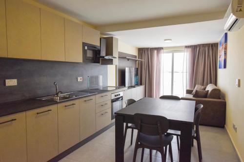 a kitchen and dining room with a table and chairs at 51HH Apartments in Il-Gżira