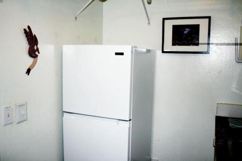 a white refrigerator in a kitchen with a lizard on the wall at Work and Play Close to Sedona in Clarkdale