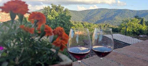 two glasses of wine sitting on a ledge with flowers at Appartamento Iesa in Lama