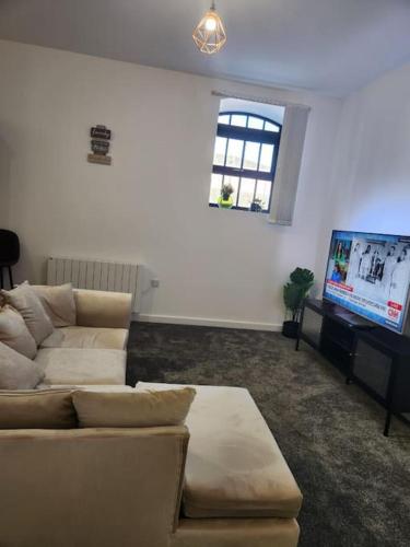 a living room with a couch and a flat screen tv at Home away from Home in Burton upon Trent