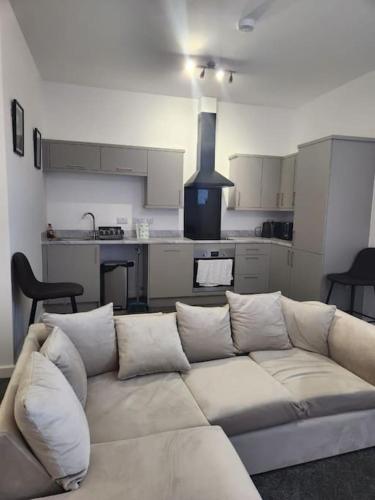 a living room with a couch and a kitchen at Home away from Home in Burton upon Trent