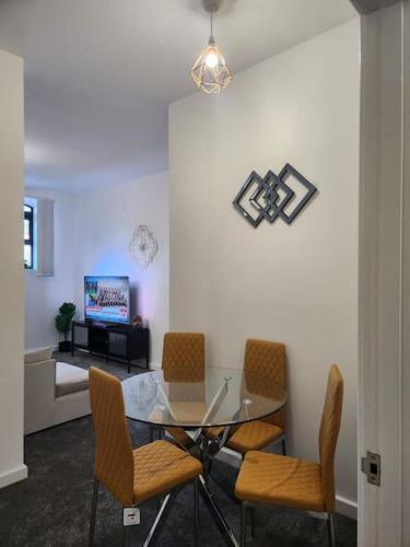 a dining room with a glass table and chairs at Home away from Home in Burton upon Trent