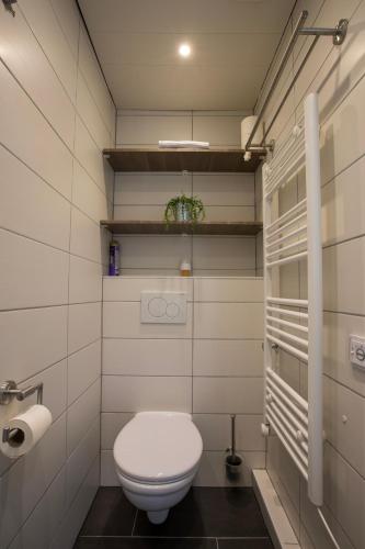 a bathroom with a toilet and a toilet paper roll at Jamies Cottage Warmenhuizen nu met airco in Warmenhuizen