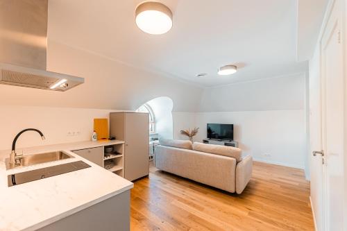 a kitchen and living room with a couch and a television at Komandandi Apartments in Kuressaare