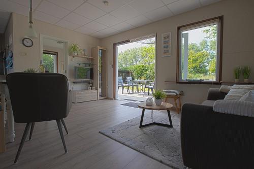 a living room with a couch and a table at Jamies Cottage Warmenhuizen nu met airco in Warmenhuizen