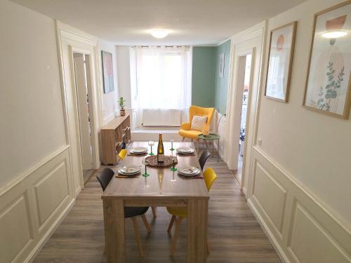 a dining room with a table and chairs in it at La Bohème - Idéal familles, hyper centre in Mulhouse