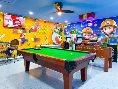 a room with a pool table in a room with cartoons at Themed house with private Game Room and Pool in Loughman