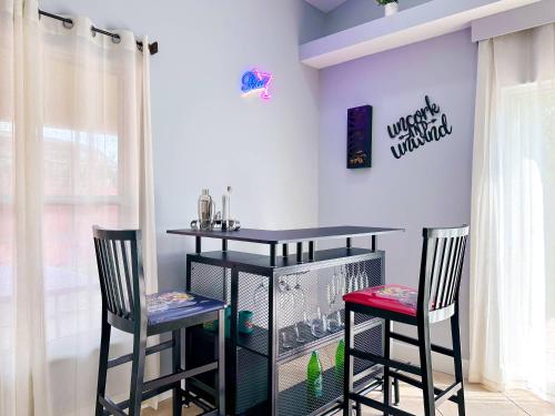 a room with two chairs and a table with a bird cage at Themed house with private Game Room and Pool in Loughman