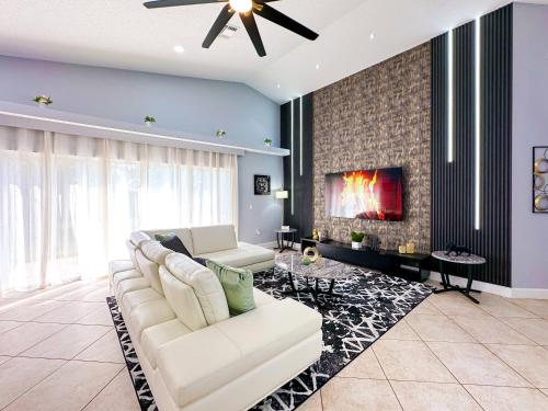 a living room with a white couch and a fireplace at Themed house with private Game Room and Pool in Loughman