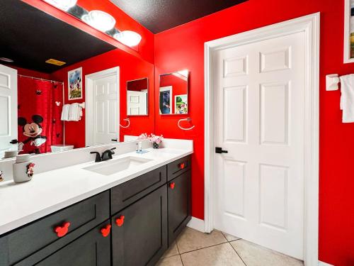 a bathroom with red walls and a white door at Themed house with private Game Room and Pool in Loughman