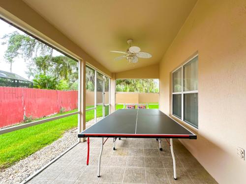 a ping pong table in a room with a patio at Themed house with private Game Room and Pool in Loughman