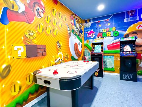 a room with a ping pong table and a video game at Themed house with private Game Room and Pool in Loughman