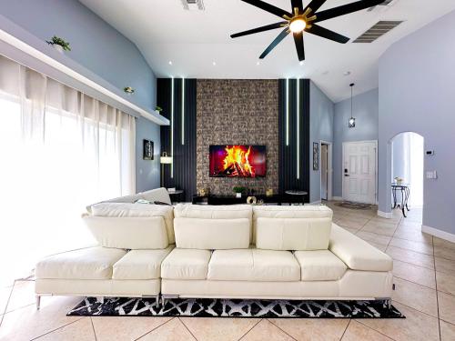 a living room with a white couch and a fireplace at Themed house with private Game Room and Pool in Loughman