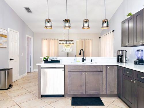 a kitchen with gray cabinets and white counter tops at Themed house with private Game Room and Pool in Loughman