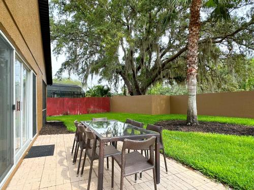 a patio with a table and chairs and a tree at Themed house with private Game Room and Pool in Loughman