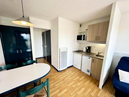 Ce petit appartement comprend une table et une cuisine. dans l'établissement Résidence Le Boucanier - 2 Pièces pour 4 Personnes 291, à Vieux-Boucau-les-Bains