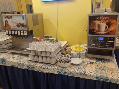 a table topped with a counter with a coffee maker and food at Hotel San Pietro in Letojanni