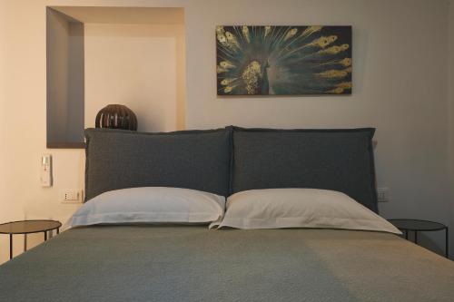 a bed with two pillows and a painting on the wall at New Moon Del prione in La Spezia