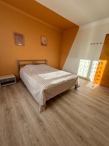 une chambre avec un lit et un parquet dans l'établissement Maison de vacance Talmont st hilaire, à Saint-Hilaire-de-Talmont