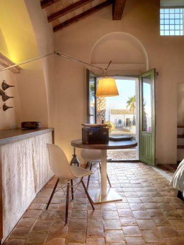 a dining room with a table and chairs and a window at Torre Fiore Hotel Masseria in Pisticci