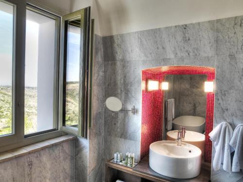 a bathroom with a sink and a mirror at Torre Fiore Hotel Masseria in Pisticci