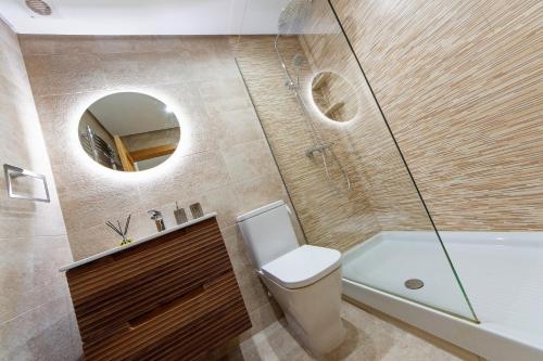 Un baño con inodoro, lavabo y espejo. en Townhouse overlooking golf course, en Las Armeras