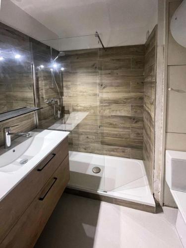 une salle de bain avec une baignoire, un lavabo et une douche dans l'établissement Résidence L'eperviere - Studio à deux pas du centre MAE-0754, aux Orres