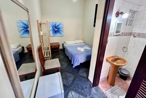 a small room with a bed and a shower at Hostel e Pousada Barra da Tijuca in Rio de Janeiro