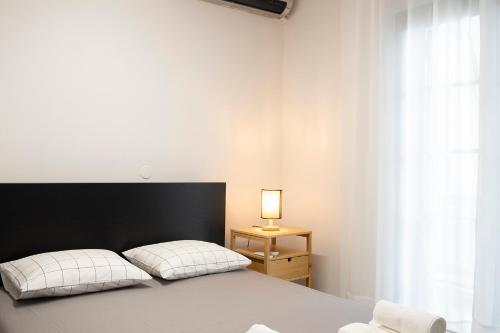 a bedroom with a bed with a black headboard and a lamp at Dimo's Apartment in Litochoro