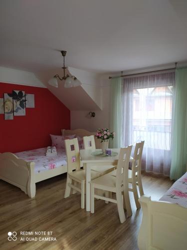 a room with a table and chairs and a bed at Willa Grono in Krościenko