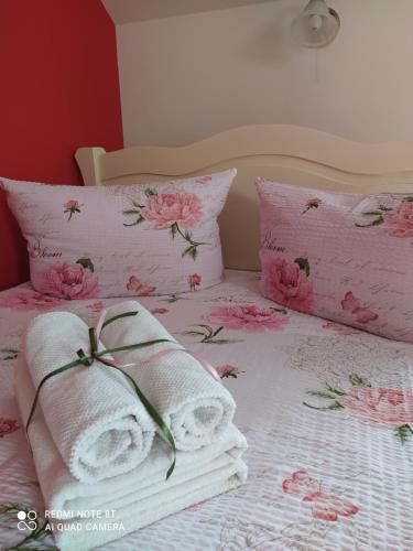 a bed with pink flowers and towels on it at Willa Grono in Krościenko