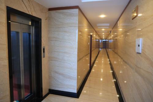 a hallway in a building with a large mirror at TCS Residency in Kanchipuram
