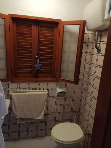 a bathroom with a toilet and a window at La casa dei Nonni in Cavo