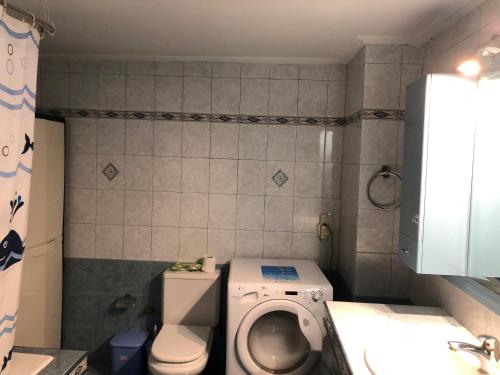 a bathroom with a toilet and a washing machine at Nafpaktos comfort guest house in Nafpaktos