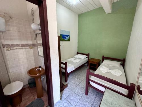 a small bathroom with two beds and a toilet at Hostel e Pousada Barra da Tijuca in Rio de Janeiro