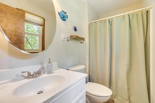 a bathroom with a sink and a toilet and a mirror at Clifton Township Home with Deck and Heated Sunroom! in Gouldsboro