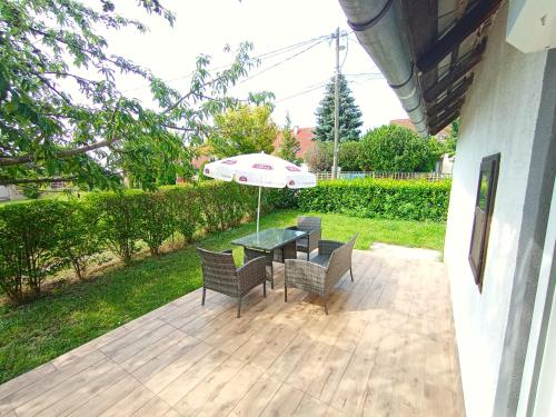 a patio with a table and chairs with an umbrella at Vadvirág Ház in Balatonfüred