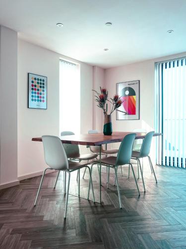 a dining room with a table and chairs at Luxe Penthouse Retreat: With Free Parking! in Brentford
