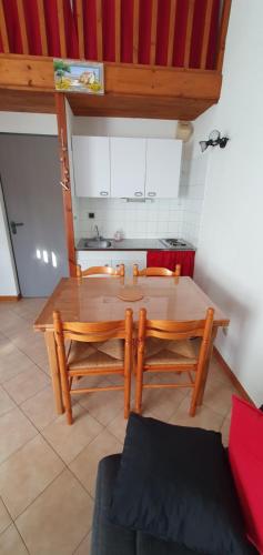 une cuisine avec une table en bois et deux chaises dans l'établissement Appartement Sainte Marie de Campan, à Sainte-Marie-de-Campan