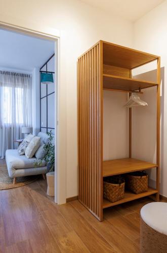 a living room with a couch and a book shelf at Hygge al Conero - Marcelli in Marcelli