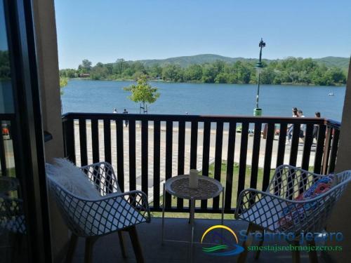 a balcony with a table and chairs and a view of a lake at Ferias Apartmani in Ostrovo