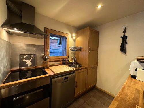 une cuisine avec un évier et une cuisinière four supérieur dans l'établissement Résidence Le Flocon Ii - CHALET LE FLOCON Tout inclus MAE-1361, à Vars
