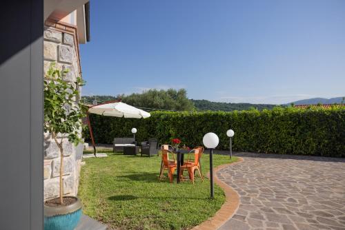 a patio with a table and chairs and an umbrella at Scario Club in San Giovanni a Piro