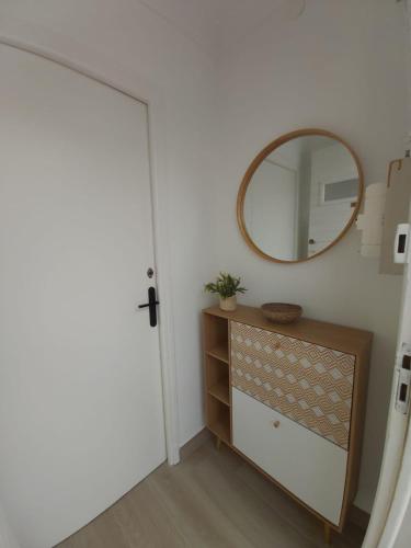 Cette chambre comprend un miroir, une commode et une porte. dans l'établissement Appartement T2 Vu mer rénové entièrement, à Saint-Cyprien