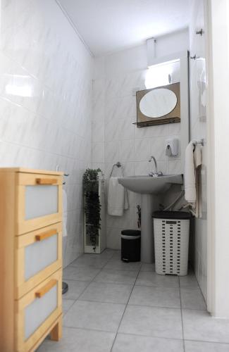 a white bathroom with a sink and a mirror at Napa City Apartments in Ayia Napa