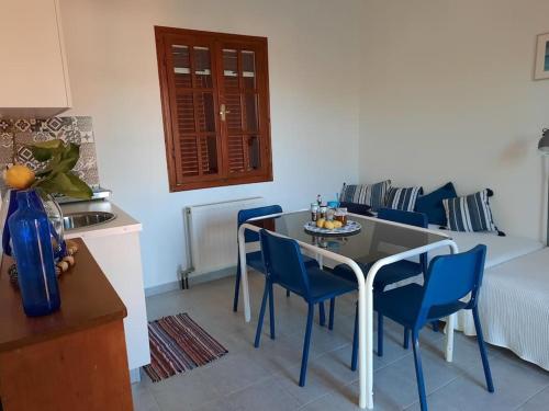 a kitchen and dining room with a table and blue chairs at Le Bellevue in Mavráta