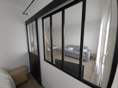 un salon avec un canapé et une fenêtre dans l'établissement Appartement T2 Vu mer rénové entièrement, à Saint-Cyprien